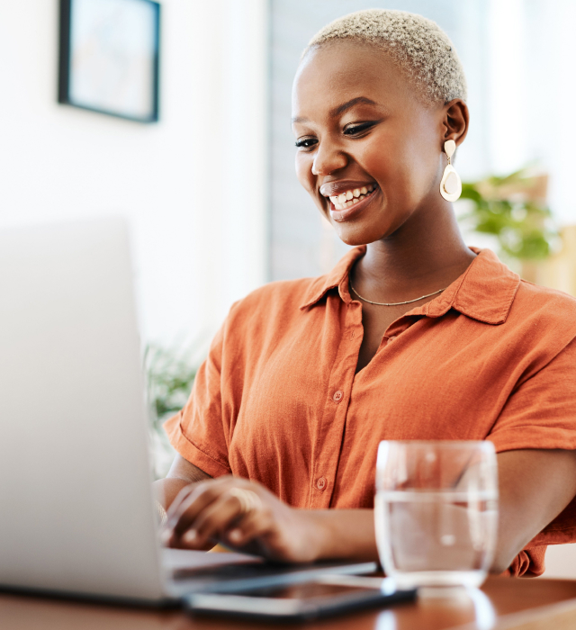 Woman smiling as she looks at her laptop